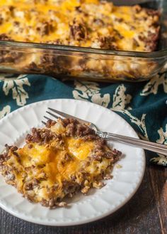 a white plate topped with a casserole covered in ground beef and melted cheese