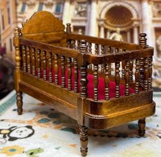 a miniature wooden crib sitting on top of a rug