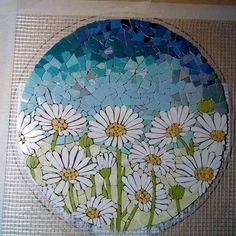 a mosaic plate with white daisies on it