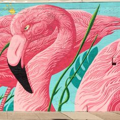 a large pink flamingo painted on the side of a building