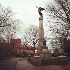 a statue with an eagle on top in the middle of a park