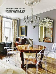 a dining room table with chairs and a chandelier hanging from the ceiling above it