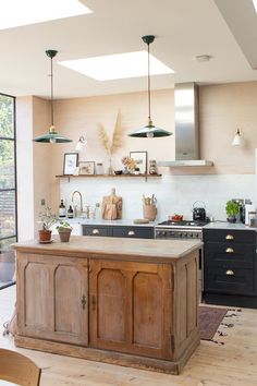 a kitchen with an island, stove and sink in it's center area next to a large window