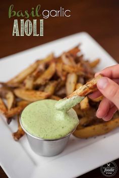 a person dipping sauce on top of french fries