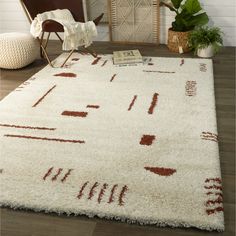 a white rug with red and brown designs on it