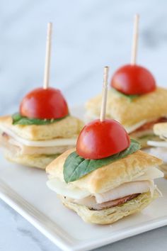 small sandwiches with tomatoes and meat on them