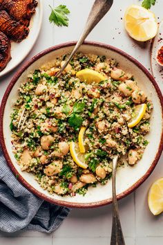 a bowl filled with rice and lemons next to meat