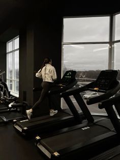 a woman running on a treadmill in a gym