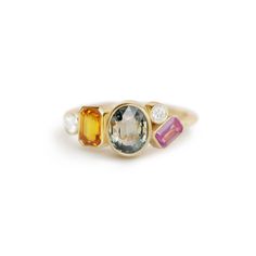 a gold ring with three different colored stones