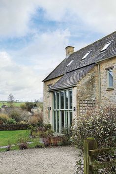 an old stone house with a gravel driveway