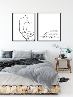 two black and white prints on the wall above a bed