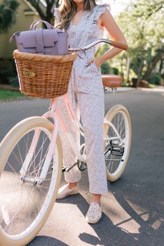 a woman standing next to a bicycle holding a basket