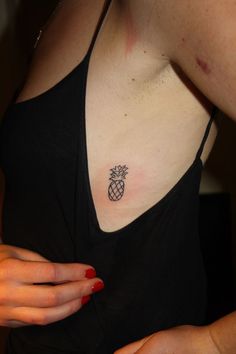 a woman with a pineapple tattoo on her upper arm and chest, showing it's small ribcage