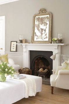 a living room filled with furniture and a fire place under a painting on the wall