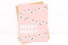 a pink christmas card that says merry merry on the front and bottom with small lights strung across it