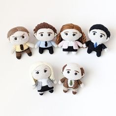 six small crocheted dolls are arranged in the shape of four different people, one is wearing a suit and tie