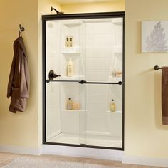 a bath room with a walk in shower next to a towel rack and two towels