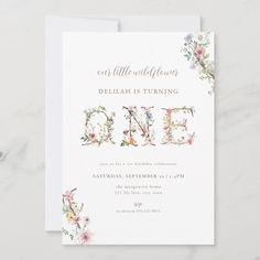 a floral birthday party card with the word'one'written in cursive letters