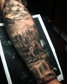 a man with a bear and waterfall tattoo on his arm