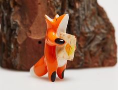 a small figurine of a fox holding a piece of cheese