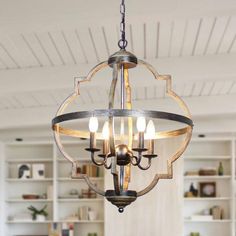 a chandelier hanging from the ceiling in a room with white walls and open shelving