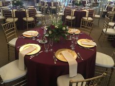 the table is set with gold and white plates, silverware, and red napkins