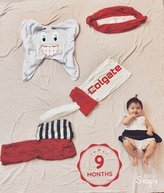 a baby laying on top of a bed next to other items