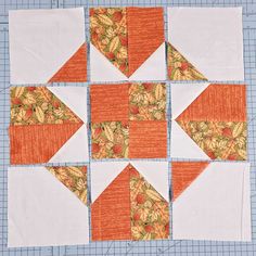 an orange and white quilted block with leaves on it