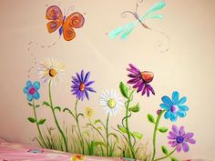 colorful flowers and dragonflies painted on the wall in a child's room with pink bedding