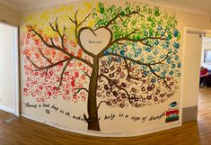 a large mural in the shape of a tree with hearts and words painted on it