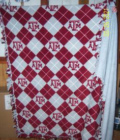 a red and white blanket with the letters mm on it, hanging from a wall