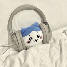 a stuffed animal with headphones on top of a bed