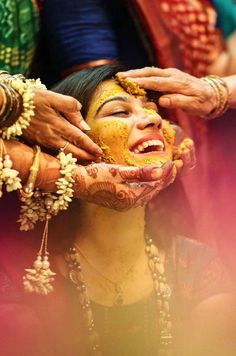 a woman is getting her face painted yellow