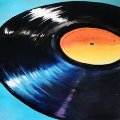 an old record player with blue and yellow vinyl on it's side, in front of a blue background