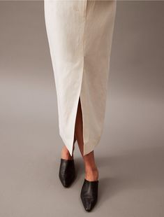 A modern midi skirt with a tailored look in a soft linen blend. Finished with tonal stitching for a clean look and a vented front for easy movement.  Material: 40% Cupro, 35% Linen, 25% Cotton. White Linen Knee-length Bottoms, Knee-length Linen Bottoms For Workwear, White Knee-length Linen Bottoms, Spring Workwear Skirt With Side Slits, Modern Asymmetrical Skirt For Office, Classic Midi-length Bottoms For Summer, Workwear Skirt With Side Slits, Beige Midi Length Bottoms For Daywear, Chic Structured Summer Bottoms