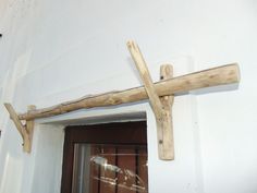 a wooden cross hanging from the side of a building