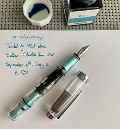 the fountain pen is next to some ink