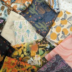 a pile of different colored and patterned fabric