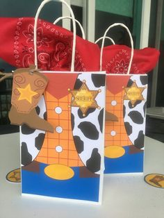 two paper bags with cowboy themed designs on them, one has a star and the other has a sheriff's badge