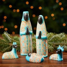 a group of blue and white ceramic items on top of a wooden table next to a christmas tree