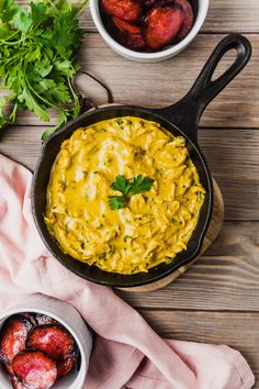 a skillet filled with yellow sauce next to bowls of peaches and parsley