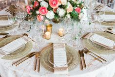 the table is set with gold plates and place settings