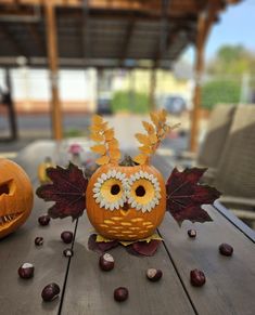 two pumpkins decorated with flowers and leaves are sitting on a table