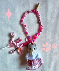 a keychain with a small stuffed animal on it's side next to a pair of scissors