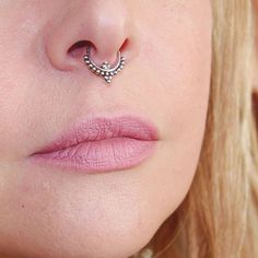 a close up of a woman's nose with a piercing in the shape of a heart