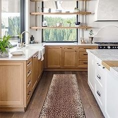 a kitchen with wooden cabinets and leopard print runner rug