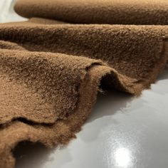 some brown fabric is laying on top of a table and it looks like they have been rolled up