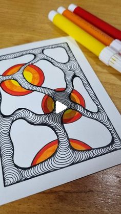 an art project with markers and pencils on a table