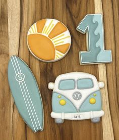 decorated cookies with the number one, surfboard and van on top are displayed next to each other