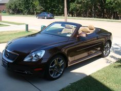 a black convertible car parked on the sidewalk